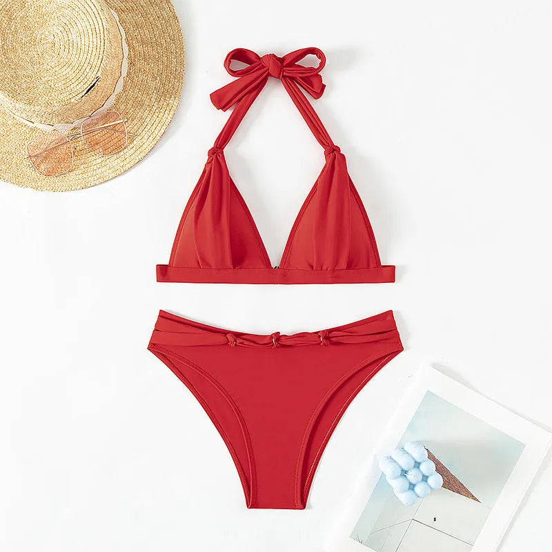Red women's lace-up halterneck bikini with split shorts on a mannequin.