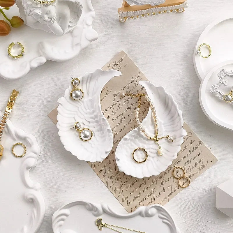 European Baroque style gypsum jewellery display plate with rings and earrings on a dressing table
