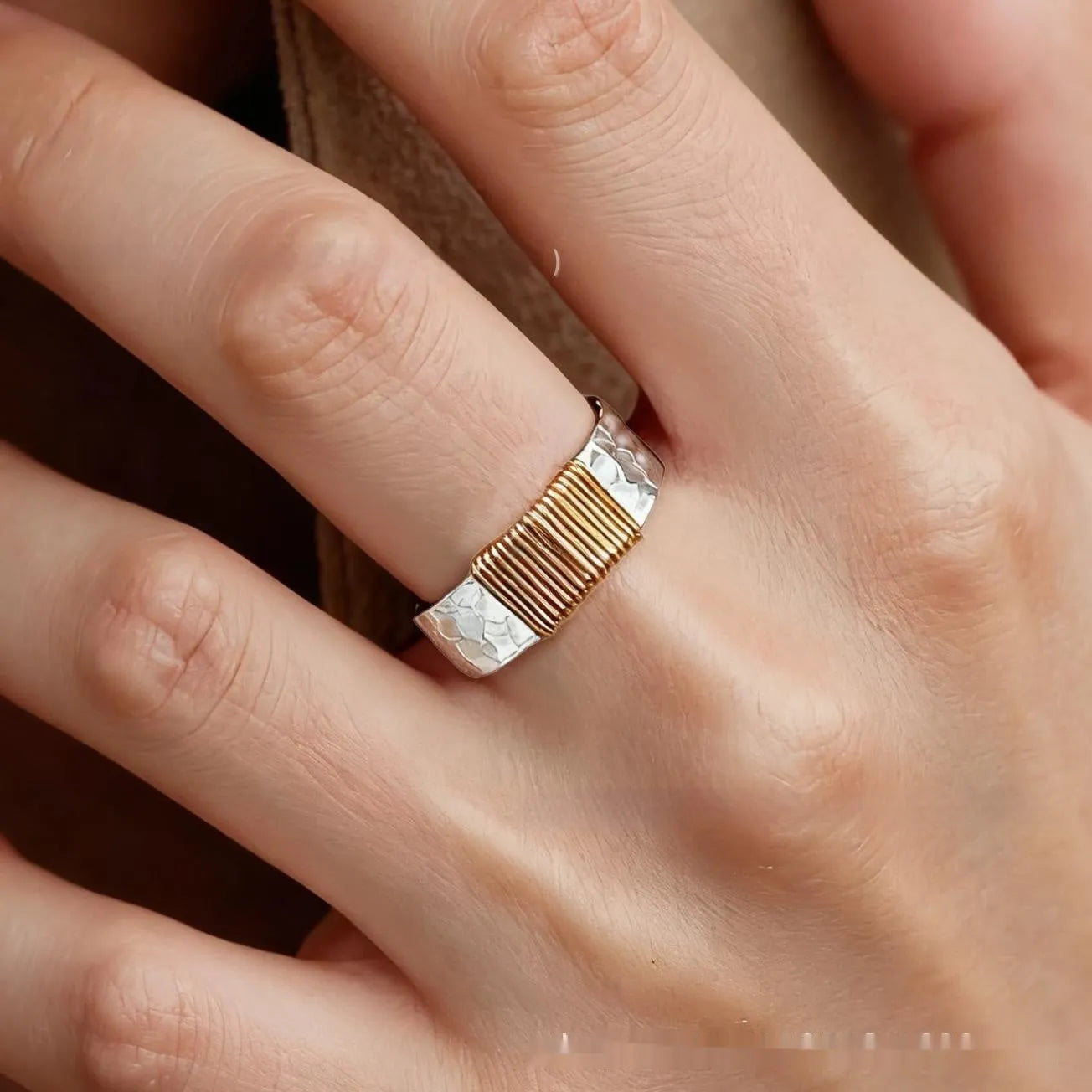 Silver golden geometric copper bracelet with an irregular coil and wide face ring design.