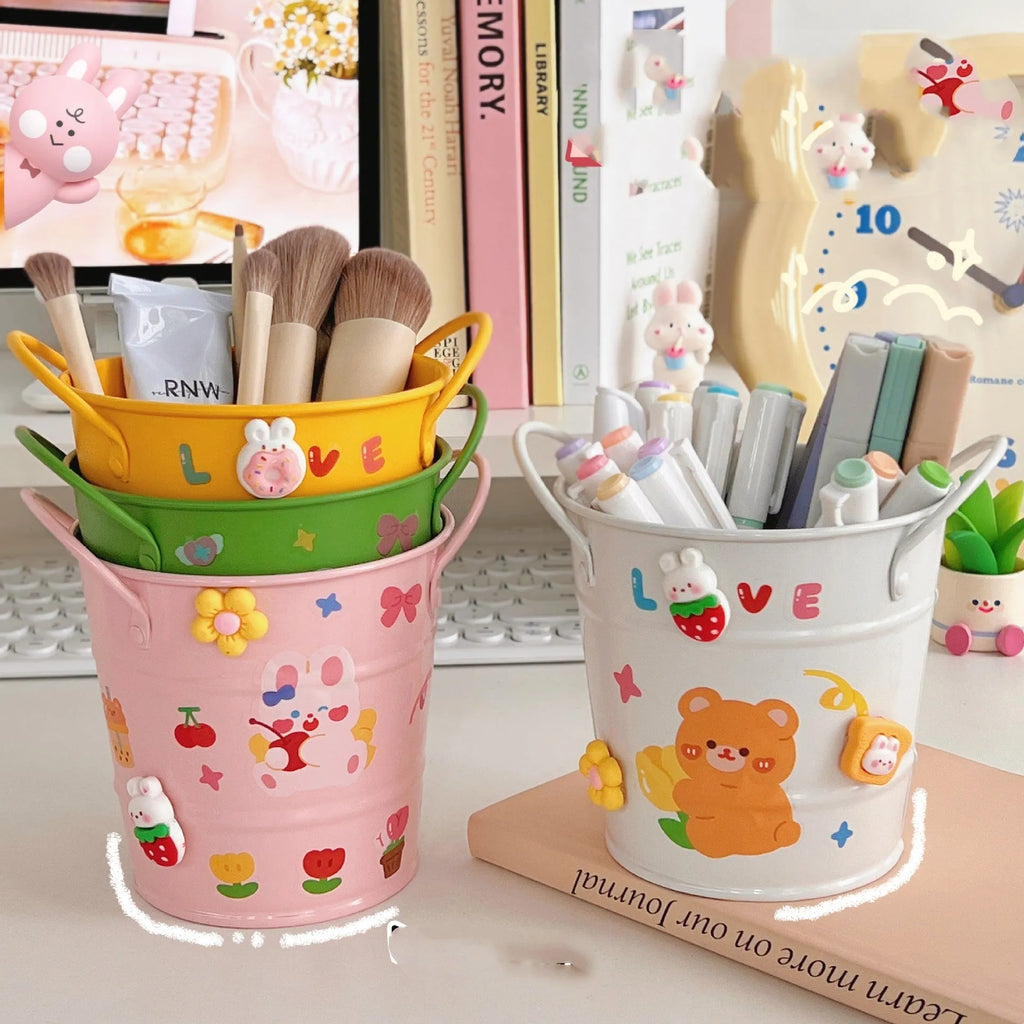 Round metal pen holder in green colour with decorative sticker patch design on desktop