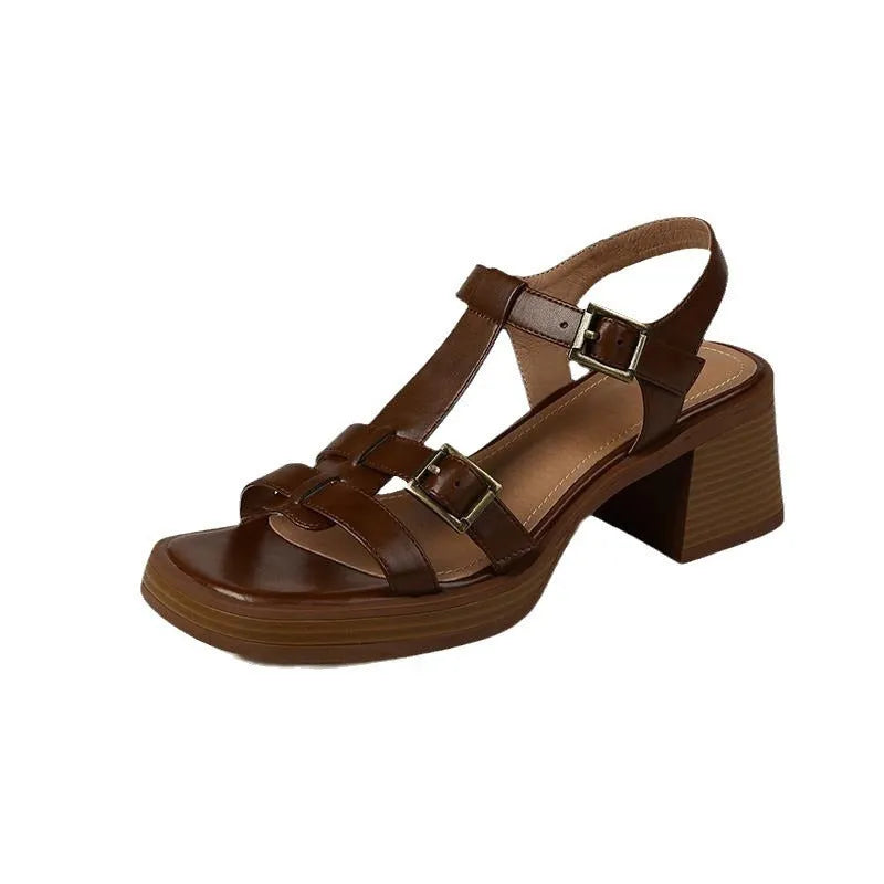 Women's black retro sandals with T-shaped buckle, chunky heel, and square open toe on a plain background.