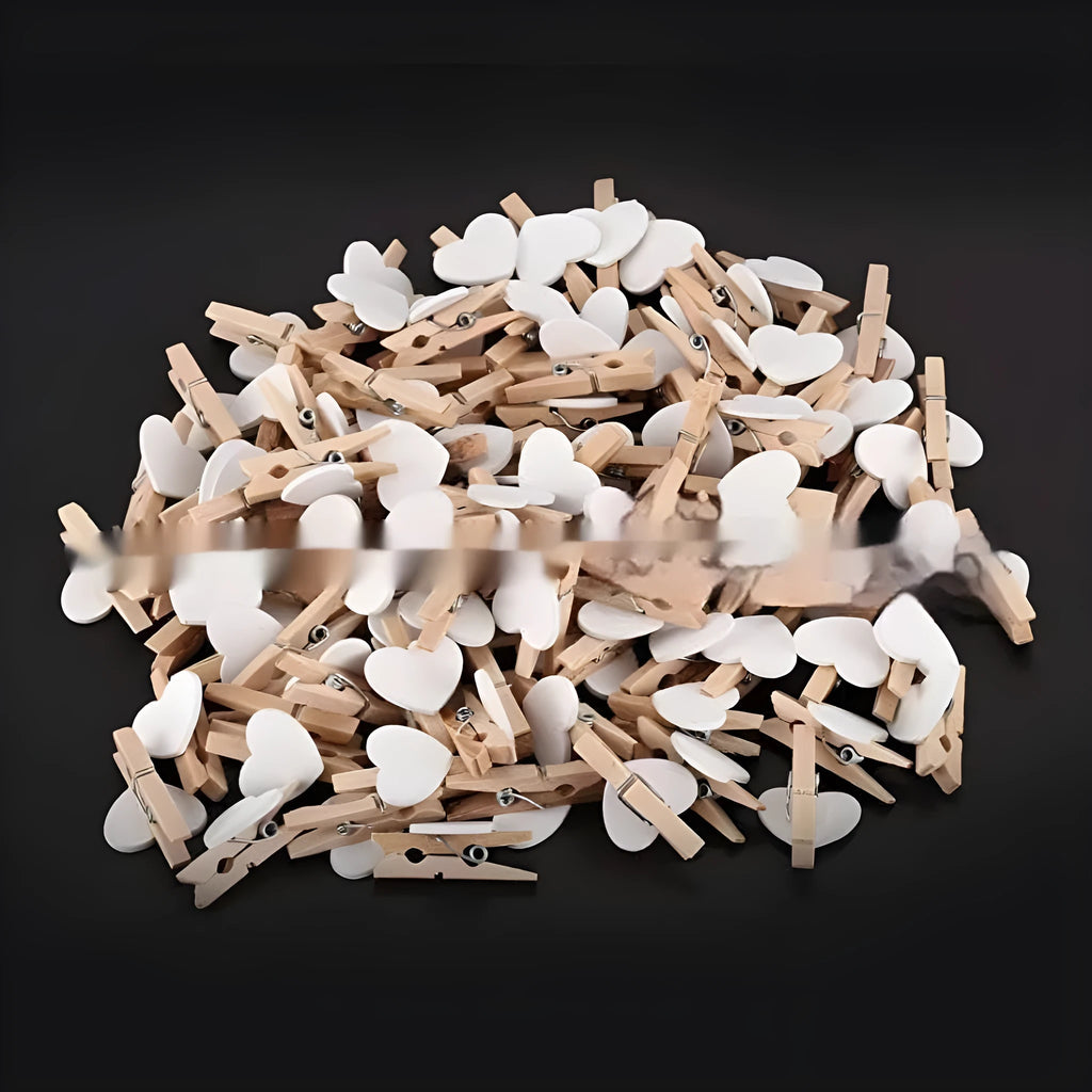 Set of five small wooden heart-shaped hair clips in various colours on a neutral background.