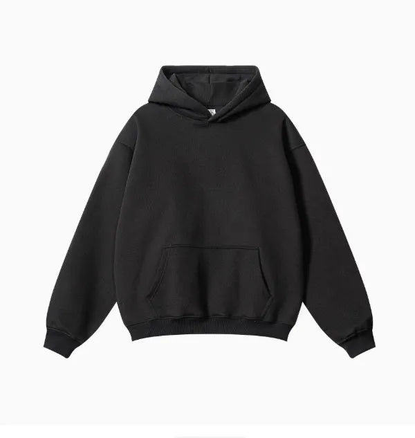 Man wearing a grey heavyweight cotton terry hooded sweater with a loose fit and drop-shoulder sleeves.