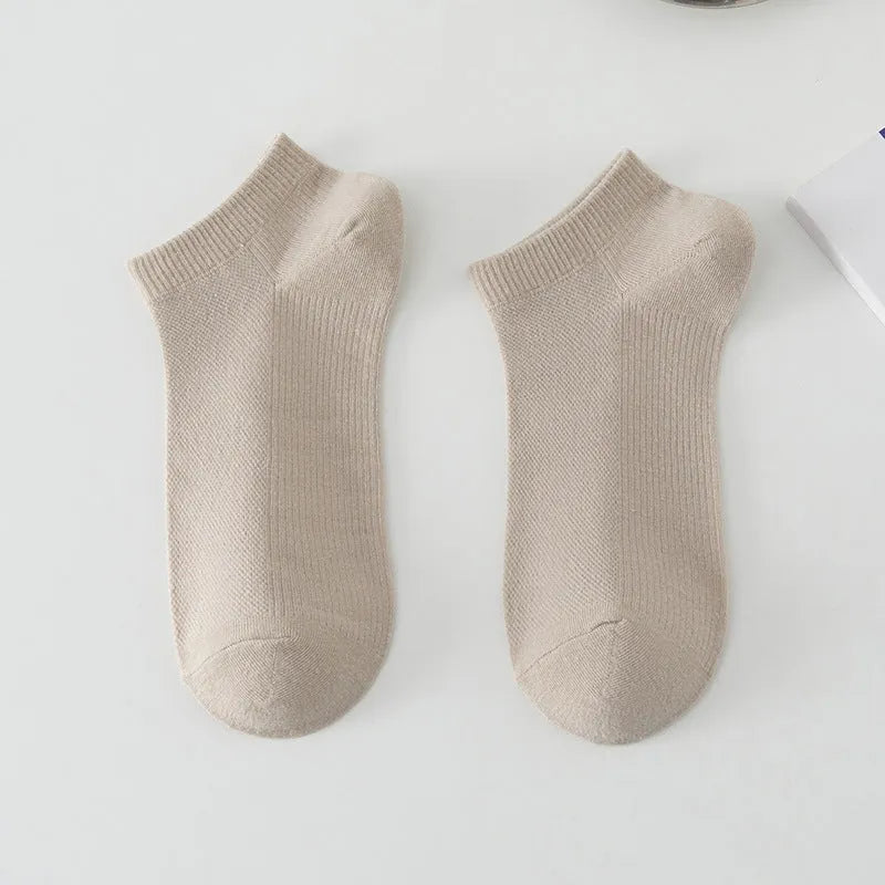 A pair of solid colour low-cut polyester boat socks for men, shown in one of six available colours.