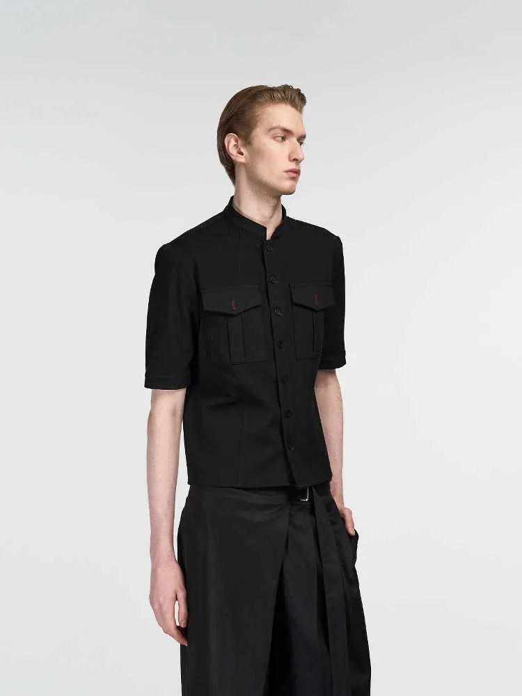 Black handmade loose fit half sleeve hunting shirt with a traditional shirt collar on a hanger.