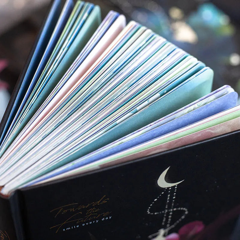 A5 scrapbook notebook with luminous cover open to show colour illustration pages, in purple colour option.