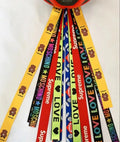 Colourful fabric helmet streamers for children's roller skating and ski helmets, shown in apricot, red, and grey.
