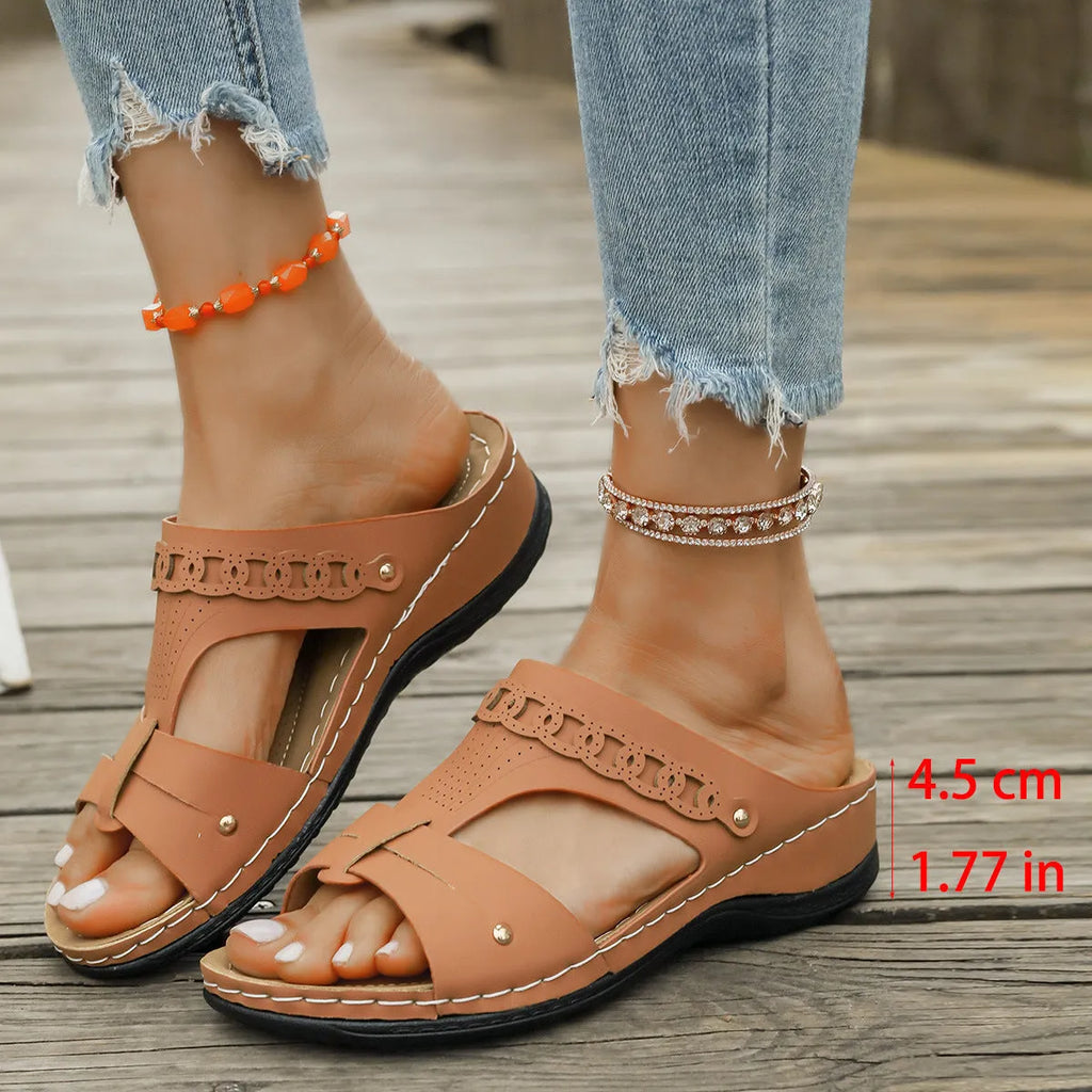 Women's beige Roman style slippers with a slope heel and fish mouth toe holder on a rubber sole.