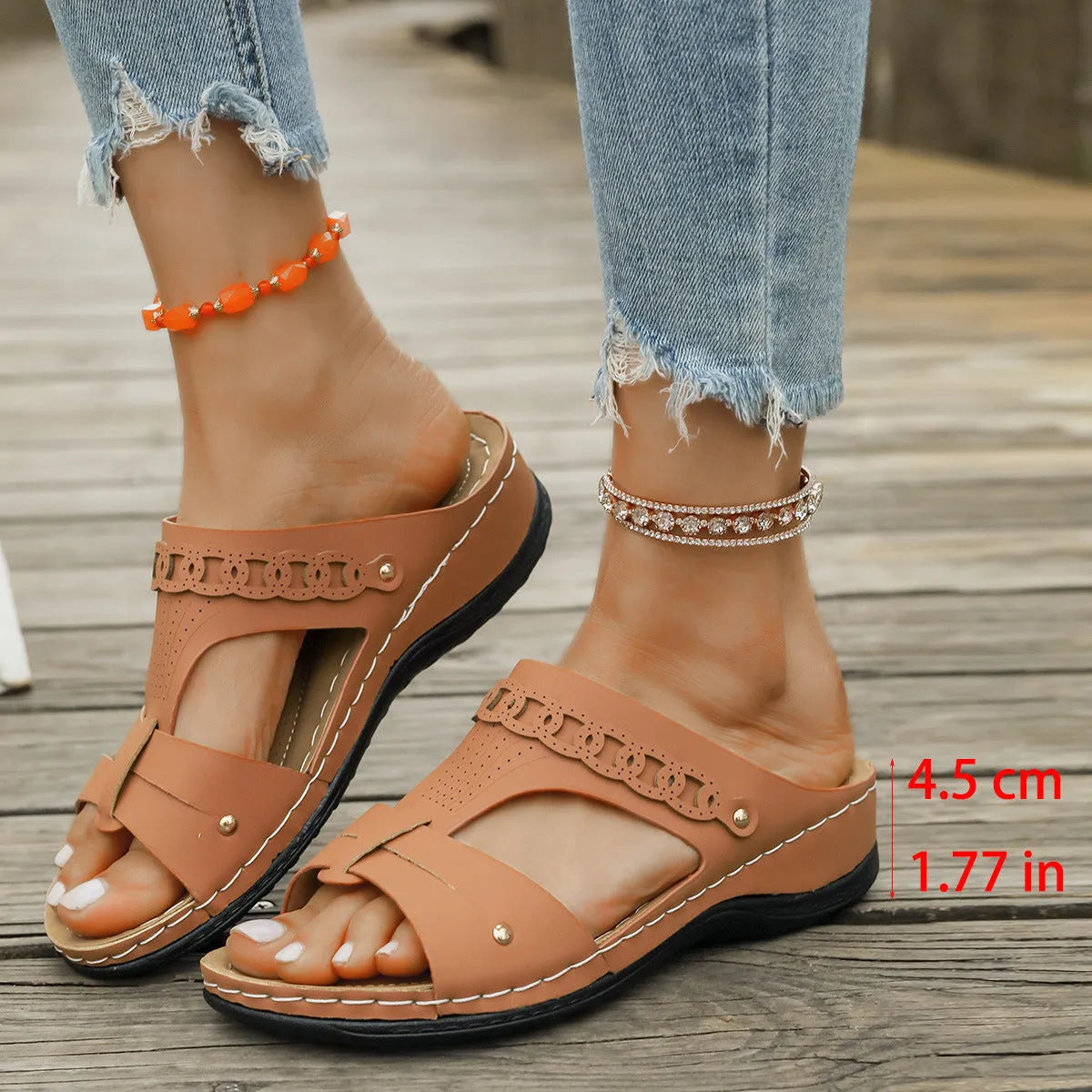 Women's beige Roman style slippers with a slope heel and fish mouth toe holder on a rubber sole.