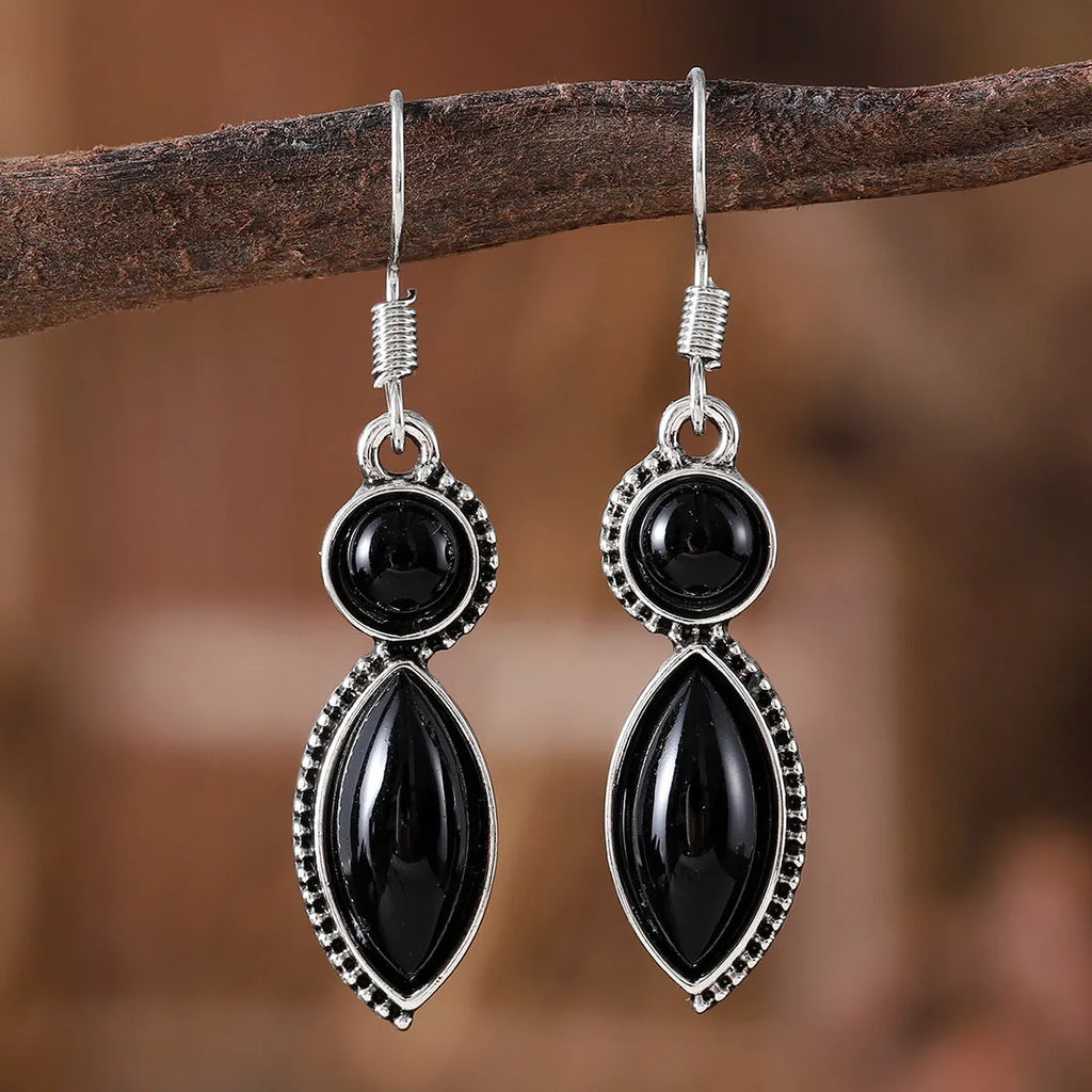 A pair of geometric vintage pendant earrings in black and purple colours with a bohemian style.