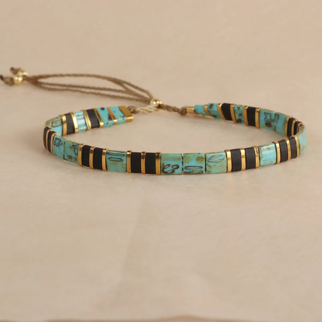 Geometric round glass bead bracelet in milky white, black, green, blue, or red.