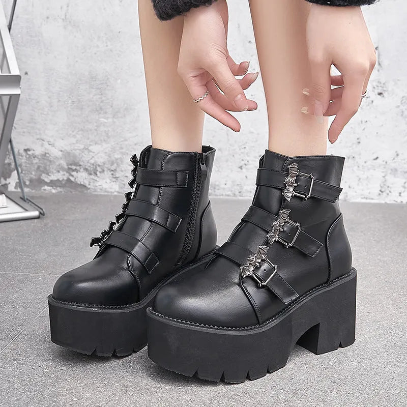 Black women's punk-style Martin ankle boots with a bat-shaped buckle and side zipper.