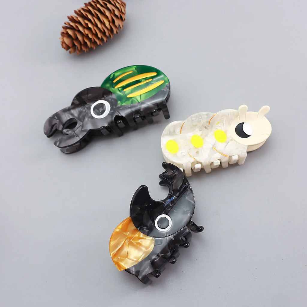 Handmade transparent acetate sheet with cartoon beetle and caterpillar illustrations for biology education