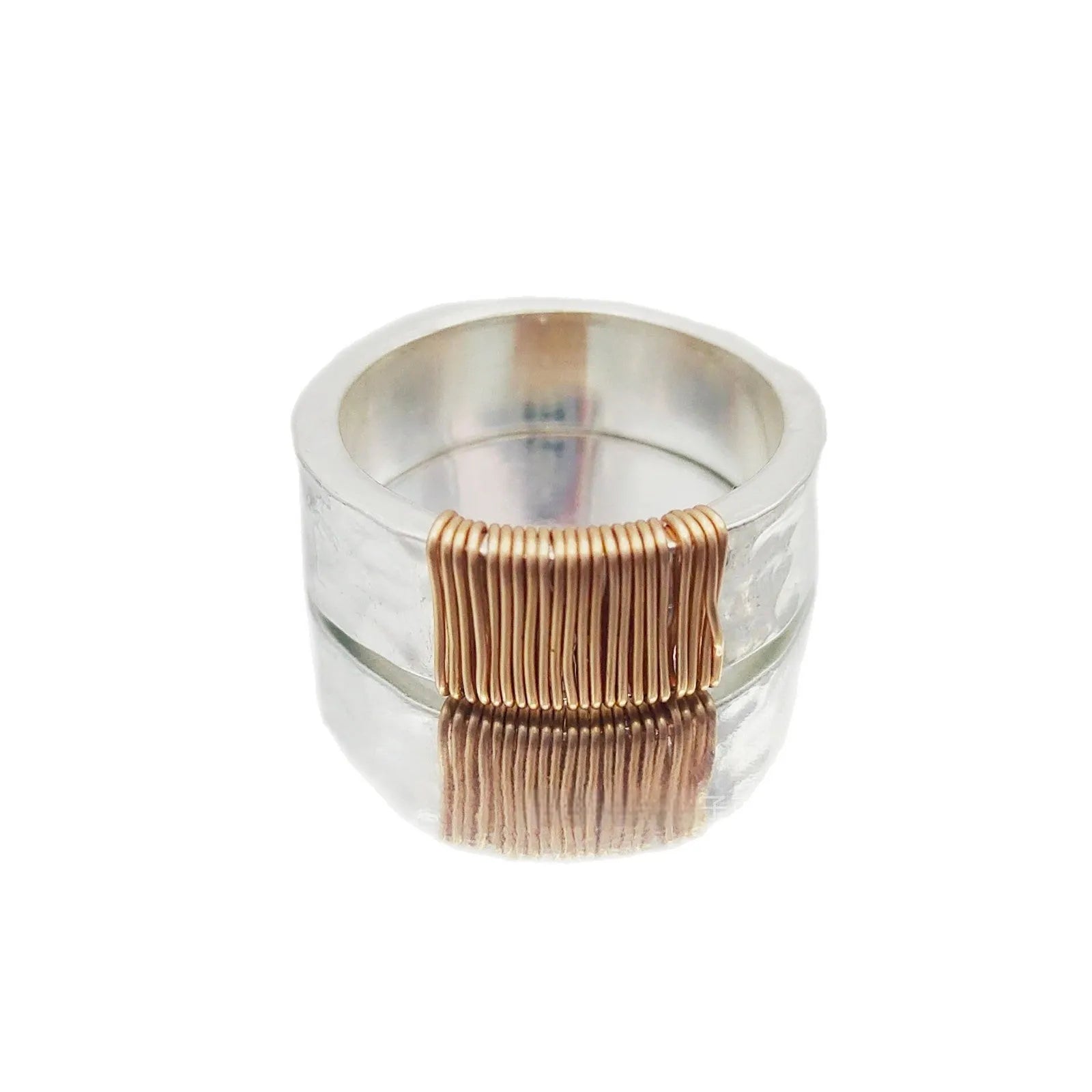 Silver golden geometric copper bracelet with an irregular coil and wide face ring design.