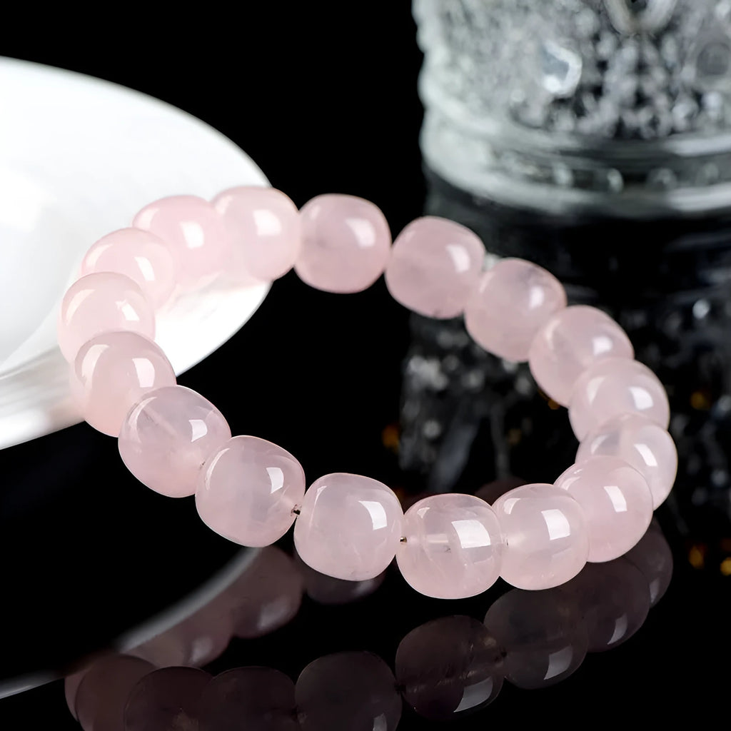 Pink natural bamboo crystal bracelet with 11-12mm geometric barrel beads on a wrist.