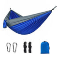 Blue parachute nylon camping hammock hung between two trees, showing its full 270cm length.
