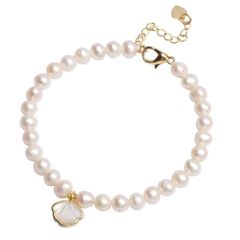 Women's freshwater pearl bracelet with a shell charm on a 16cm elastic string.
