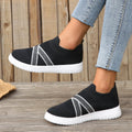 Black women's casual trainers with flyknit mesh upper, flat rubber sole, round toe, and a tassel detail.