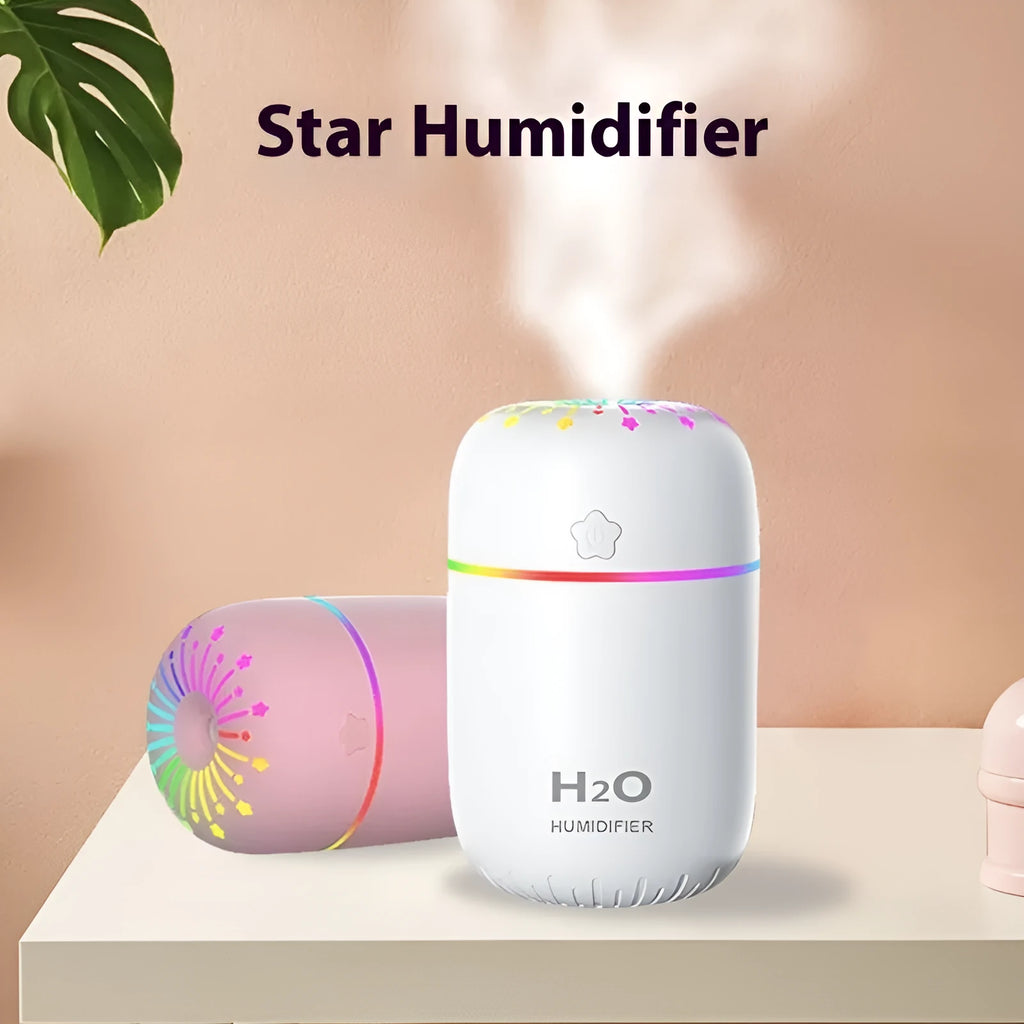 Small white USB personal humidifier with water tank on a wooden desk.