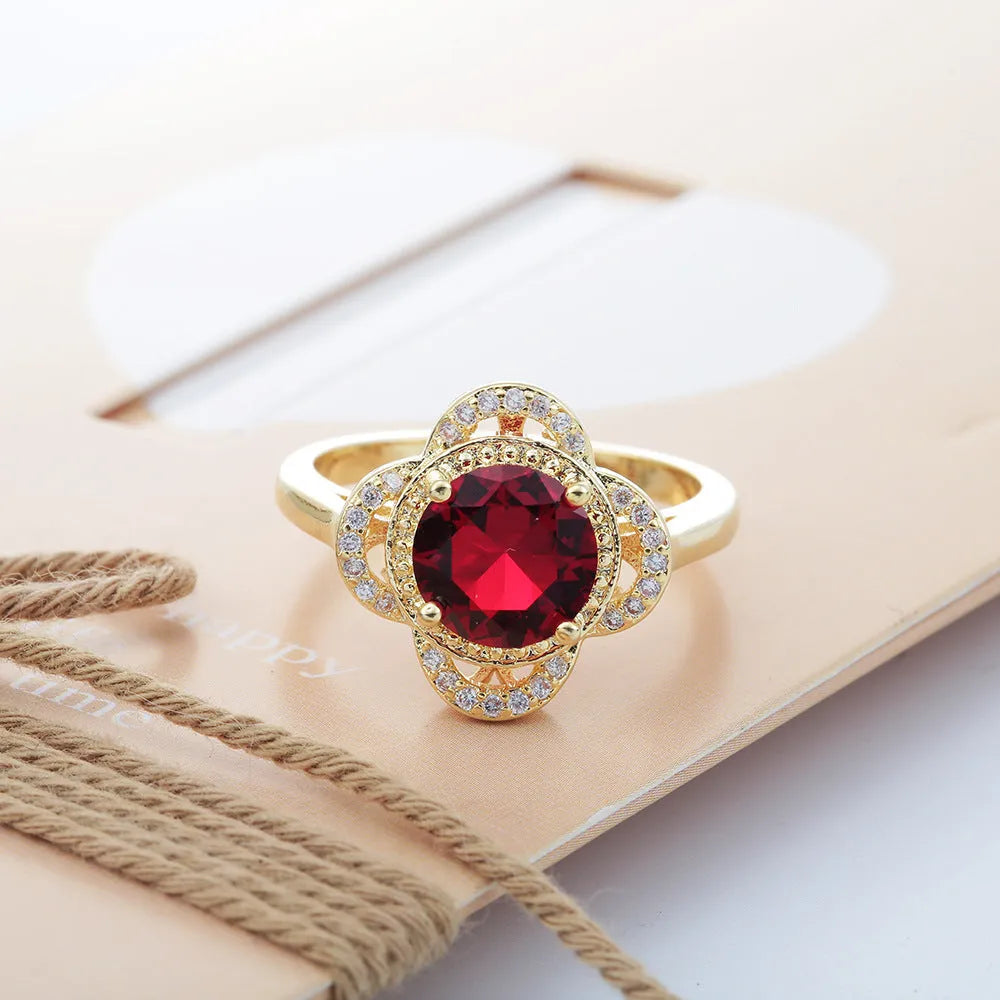 Copper ring with a zircon stone inlay in a fruit shape design on a finger.