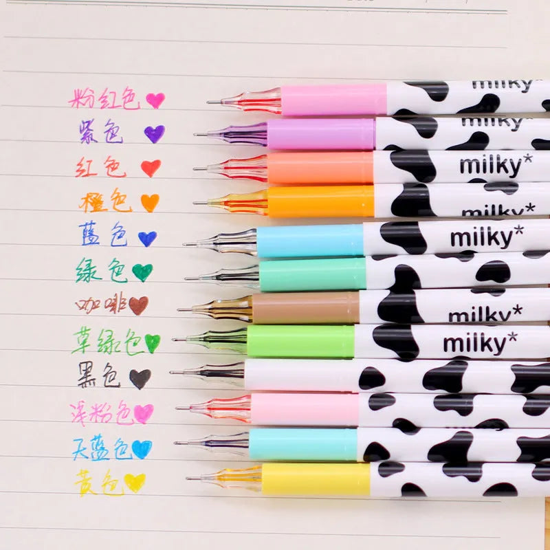 Box of 12 cow colour gel pens with 0.38mm fine tips on a desk.