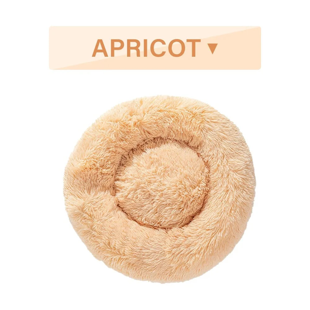Fluffy donut-shaped dog bed in long plush material, shown in a light grey colour.