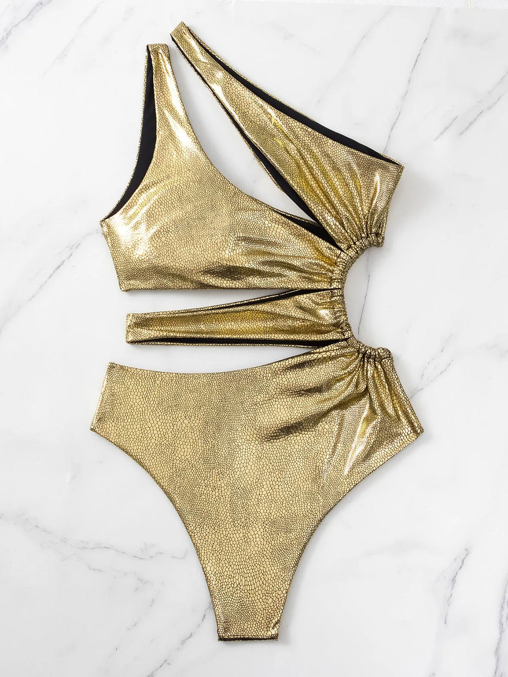 Women's gold one-piece backless swimsuit made from spandex, shown on a model.