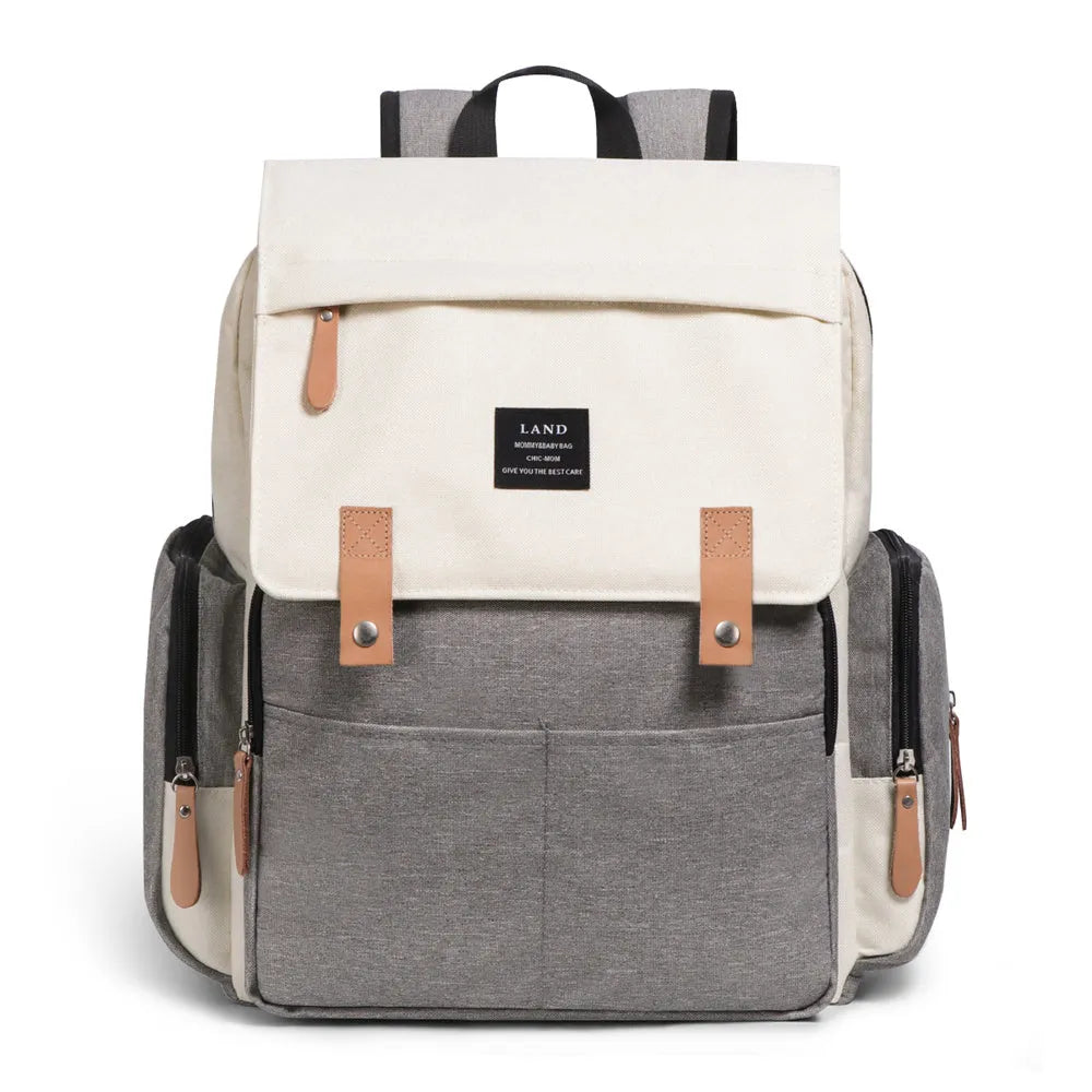 LAND Mommy large grey diaper backpack with multiple compartments and a changing mat laid out