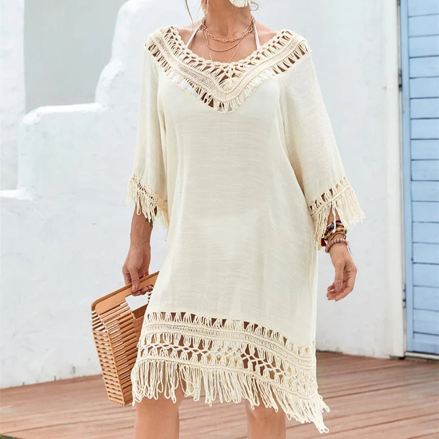 Apricot coloured crocheted knitted patchwork beach dress on a hanger, showing mid-length skirt and half sleeves.
