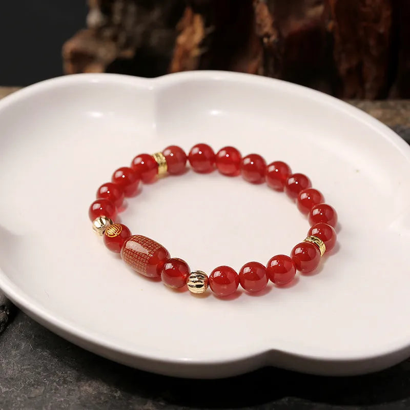 Agate Guanyin prayer bead bracelet in green or red on a wrist, showing auspicious patterns and charm.