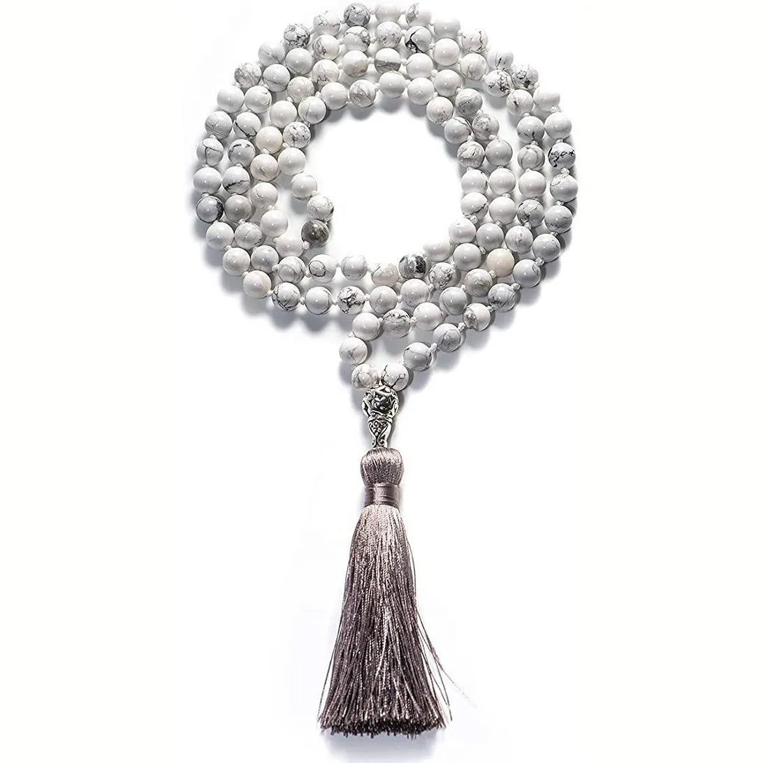 Long geometric agate and gemstone tassel necklace with blue, purple, and multi-coloured beads on a black background.