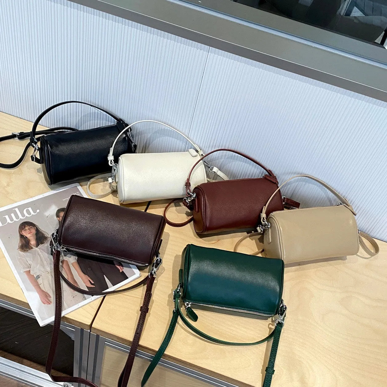 Soft brown genuine leather cylindrical crossbody phone bag with adjustable strap.