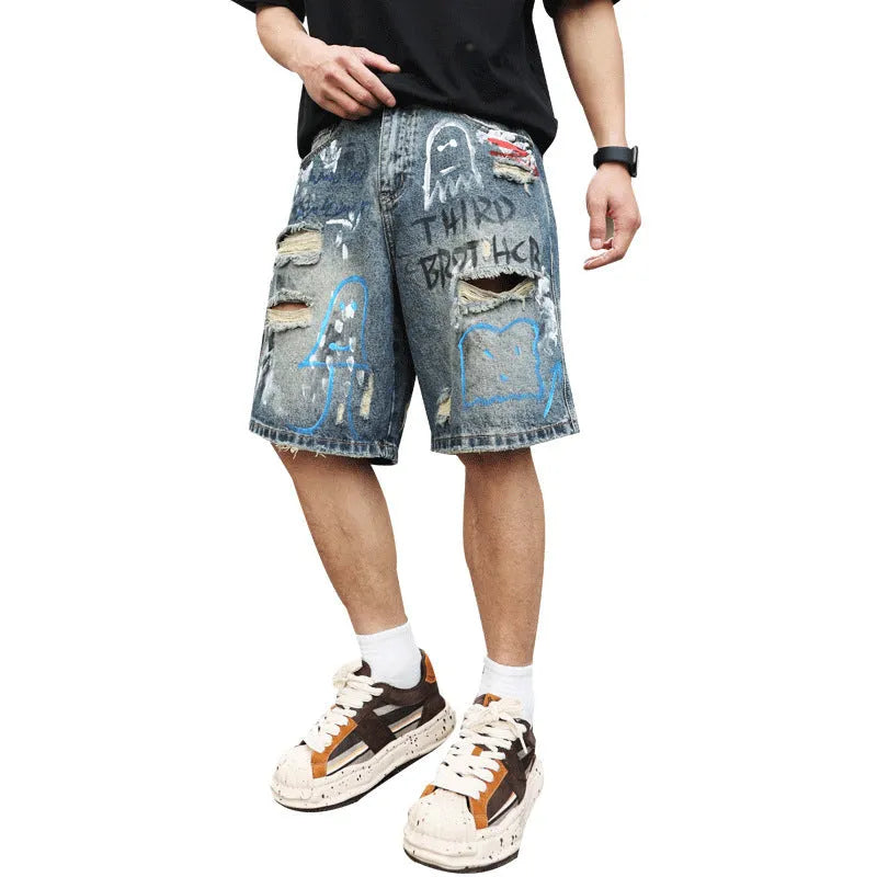 Blue men's ripped denim shorts with graffiti detailing and a straight-leg cut, showing front zipper fly.