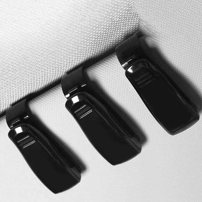 Black plastic clip for holding glasses and cards on a car sunshade