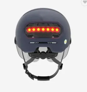 Cycling helmet with integrated red LED brake light on the back, shown in PC shell construction.