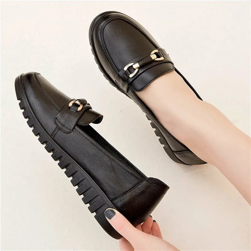 Black soft leather pumps with a round toe, low flat heel, and shallow cut design on a plain background.