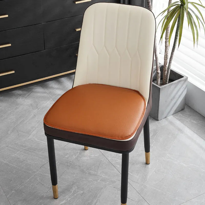 Leather horseshoe-shaped seat cushion in beige colour on a wooden chair, showing non-slip base.