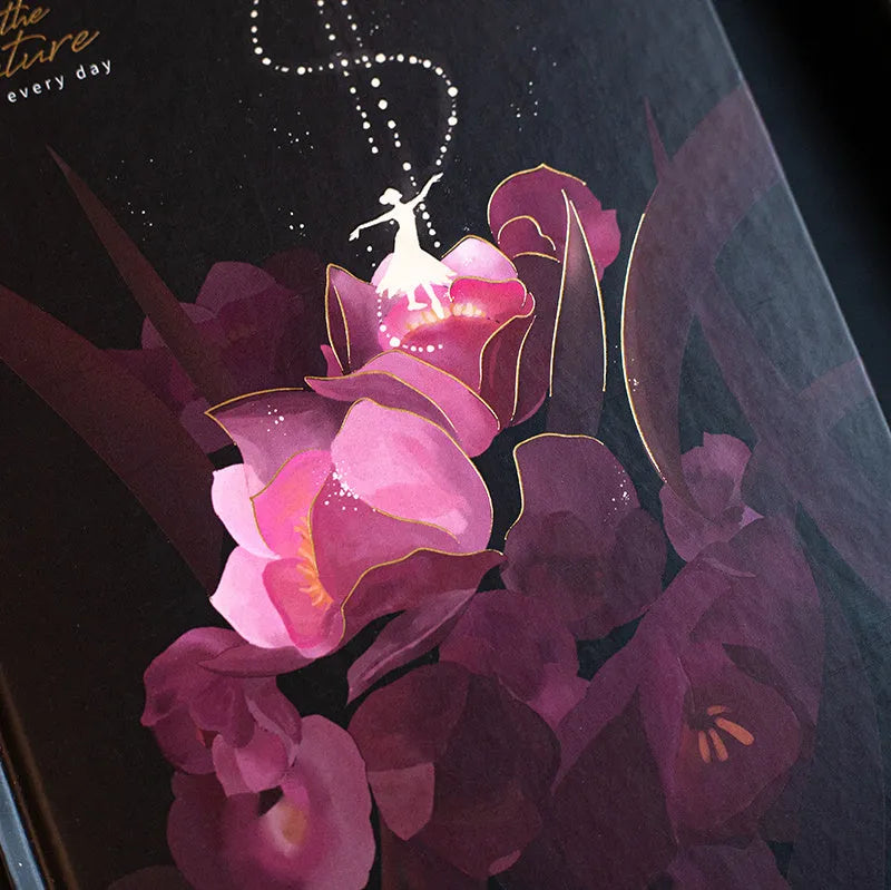 A5 scrapbook notebook with luminous cover open to show colour illustration pages, in purple colour option.