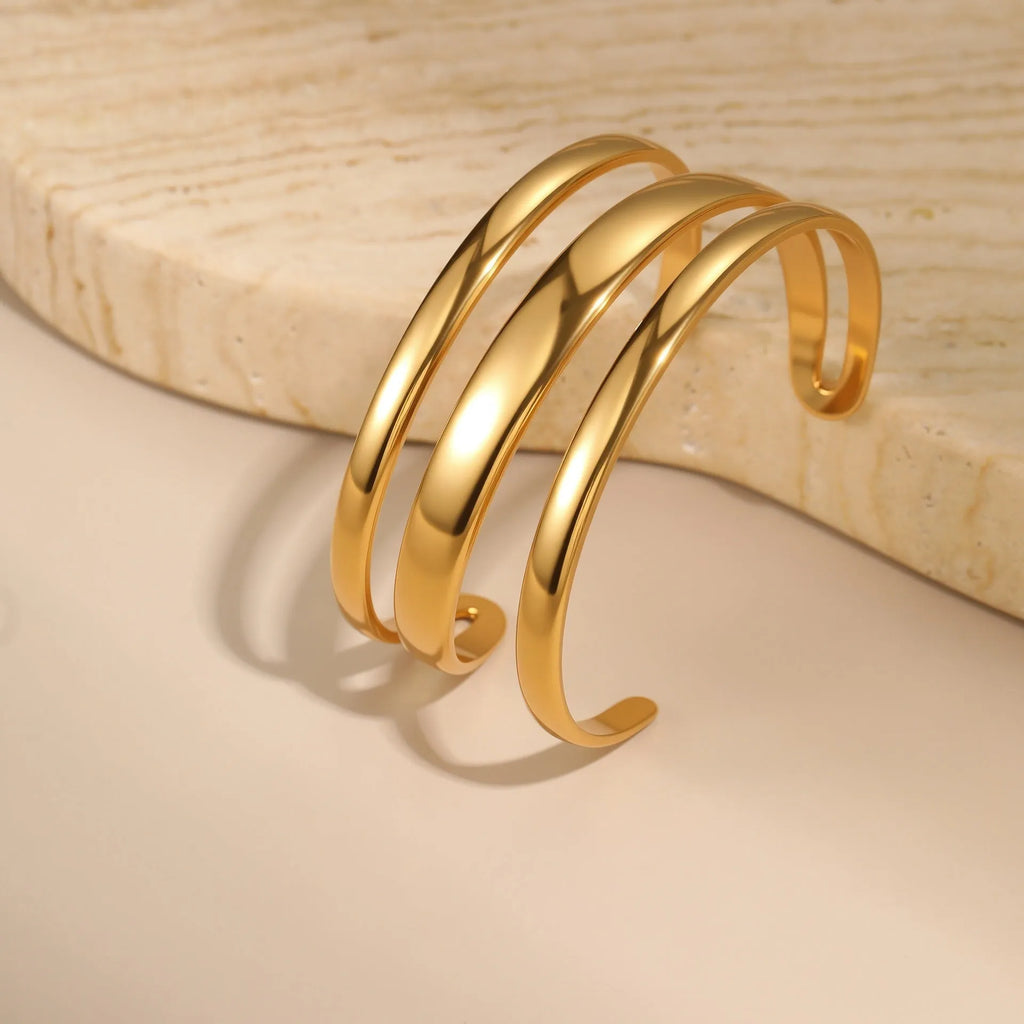 Geometric stainless steel women's bracelet with a simple opening, shown in gold and steel colour options.