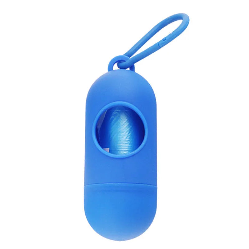 A compact black dog poop bag holder with a side hook and Velcro strap, shown next to a roll of waste bags.