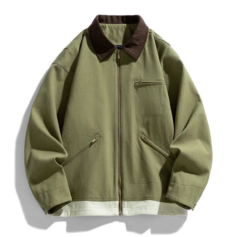 Man wearing a loose-fit mint green zip-up jacket with dark contrast lapels and side pockets.