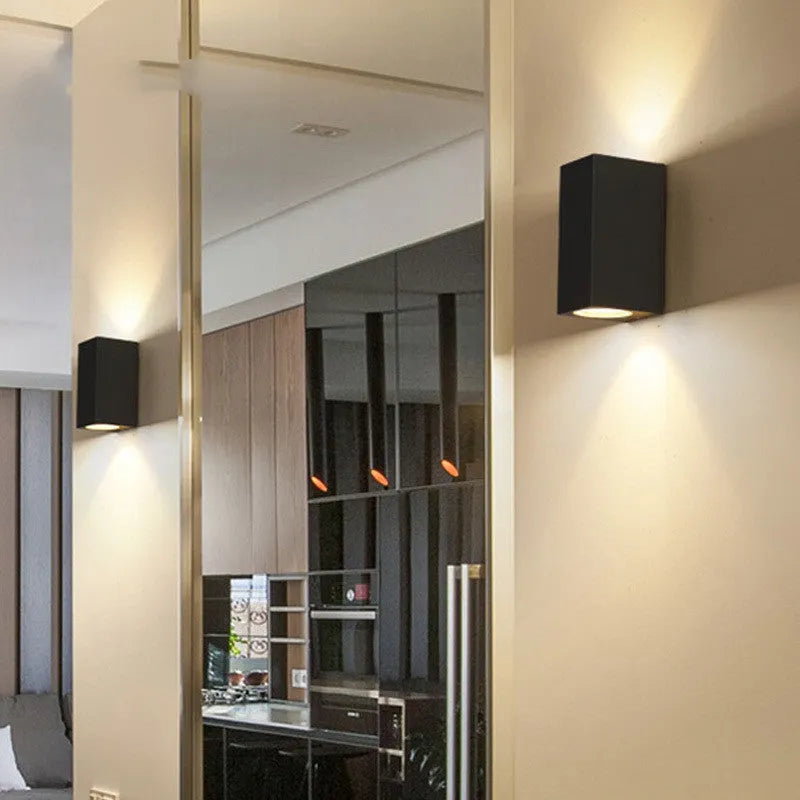 Modern black wall lamp with aluminium body, clear glass shade, and silicone rubber accents.