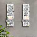 Pair of tall, silver mirror glass candlesticks designed for wall mounting in a living room.