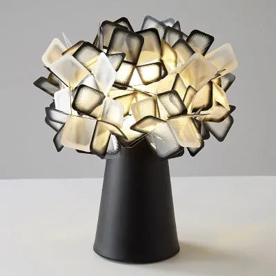Nordic style decorative table lamp with metal base in a choice of six colours on a wooden bedside table.