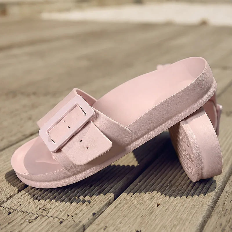 Women's grey blue buckle flip flops with a soft EVA sole on a plain background