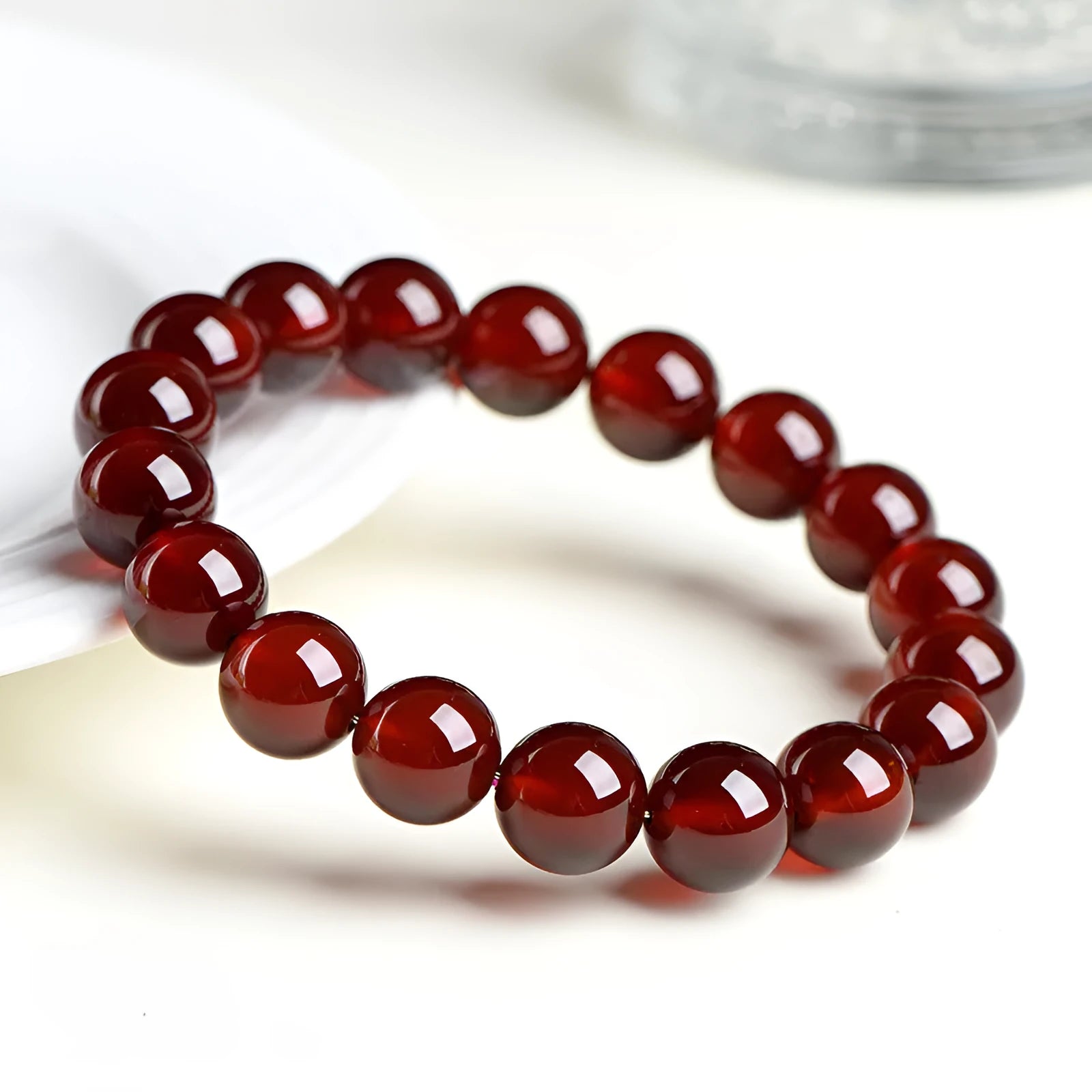 Close-up of an orange red garnet crystal bracelet with retro styling and Ruyi design details.