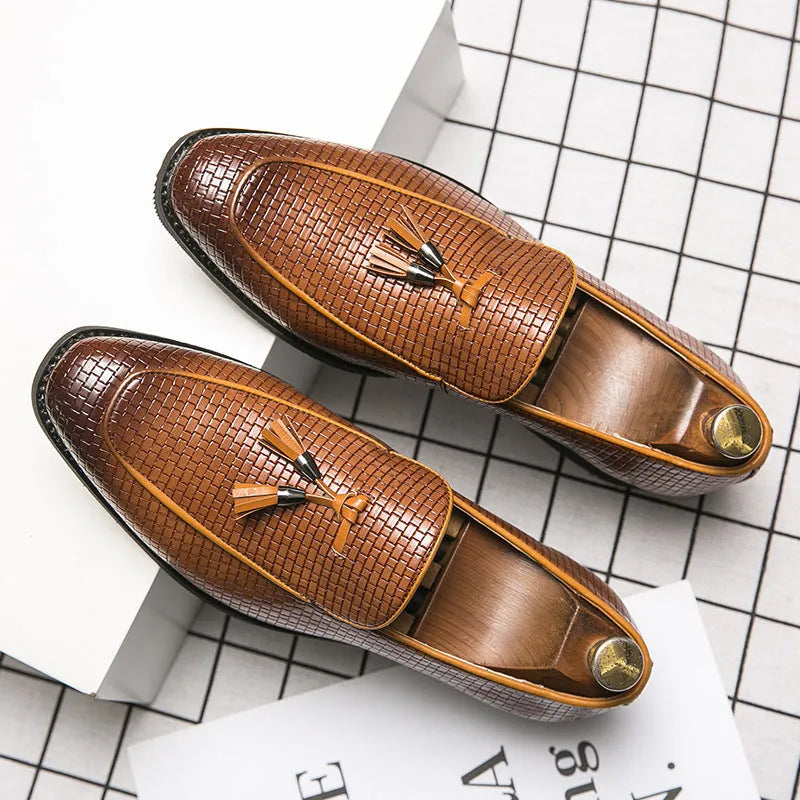 Men's black pointed-toe slip on shoes with a tassel detail on the low-top PU upper.