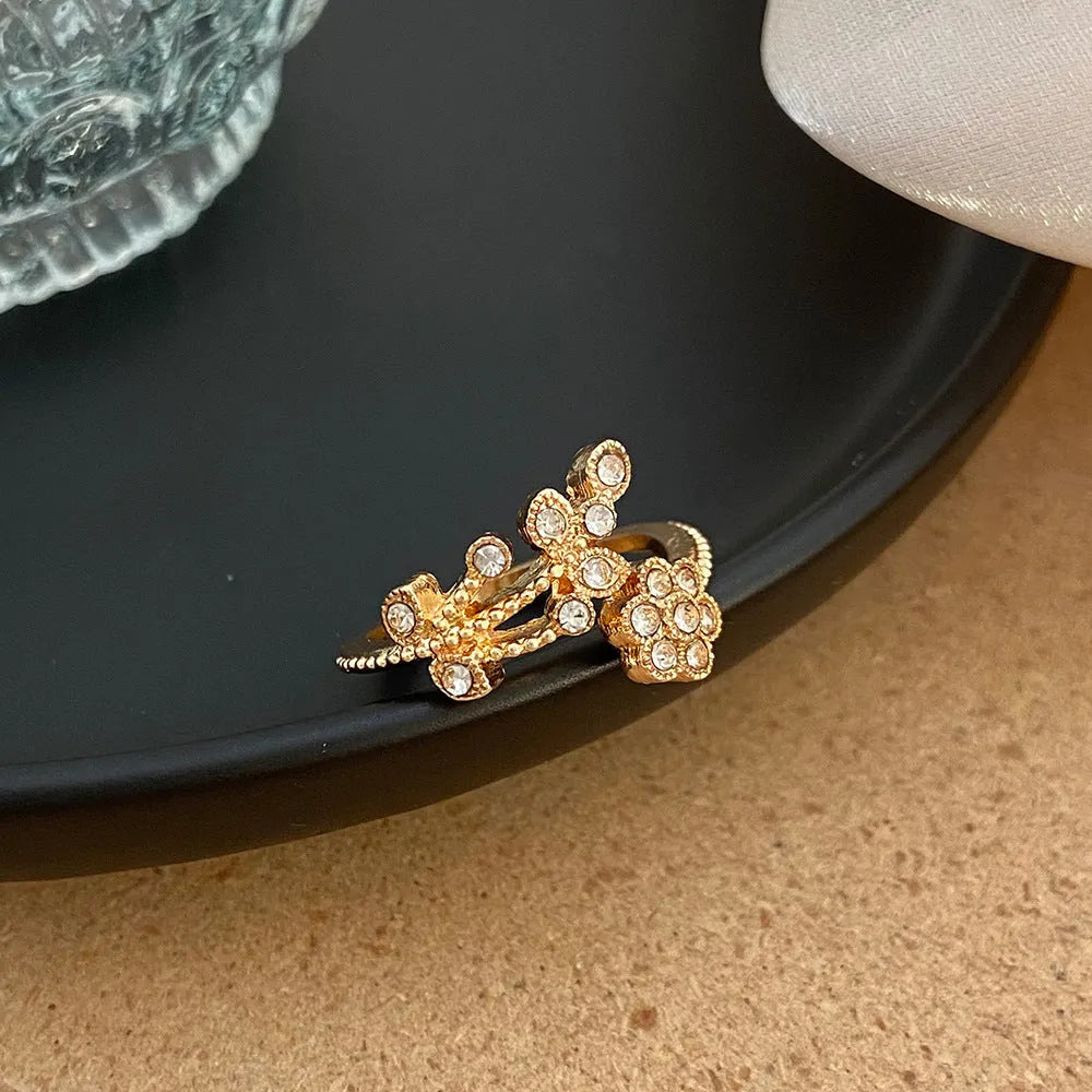 Women's open ring with diamond flower and leaf design in gold or white colour on copper material