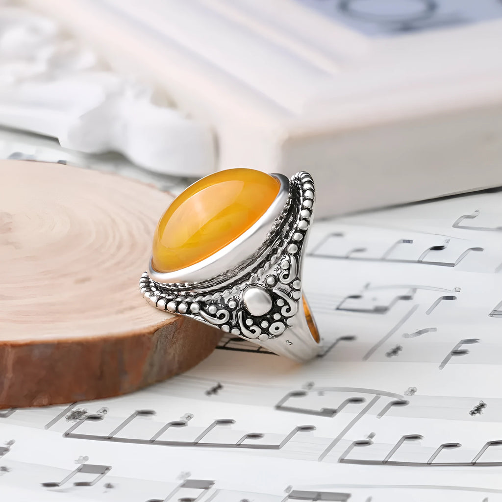 Geometric alloy ring with antique silver and amber electroplated finish shown on a hand.