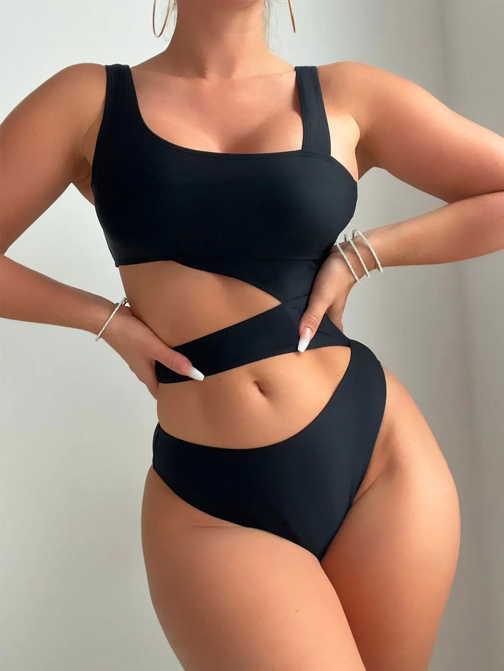 Black solid colour women's one-piece swimsuit with high-cut legs and a hollow back design.